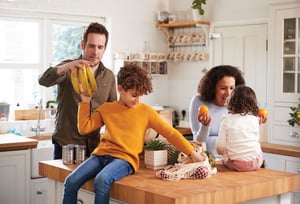 a family putting groceries away happily