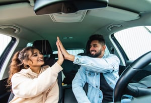Couple giving each other a high-five in their car